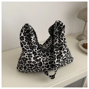 Detail of black and white leopard print nylon tote bag on a cream minimalist surface
