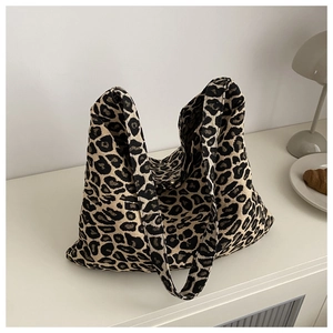 Detailed close-up of leopard print nylon tote bag texture and wide shoulder strap