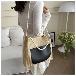 Detail view of woven tote bag showing chevron pattern texture and black leather pocket