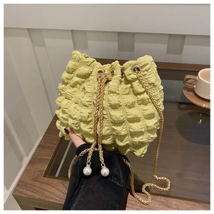 Dettaglio borsa a secchiello plissettata verde chiaro con texture a bolle e perle