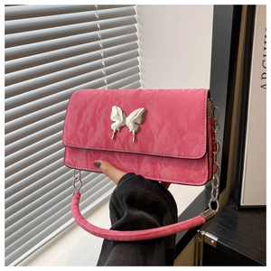 Macro detail of pink quilted bag featuring silver butterfly clasp and chunky chain strap