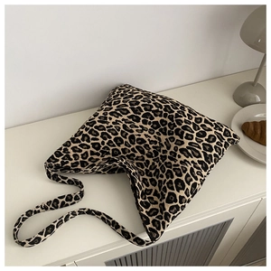 Detail shot of a leopard print nylon tote bag on a white shelf with modern home decor
