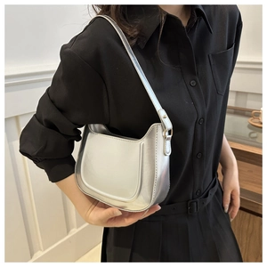 Detail of silver metallic hobo shoulder bag with crescent shape and mirror finish texture