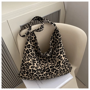 Macro detail of leopard print nylon hobo bag showing woven texture on a beige chair