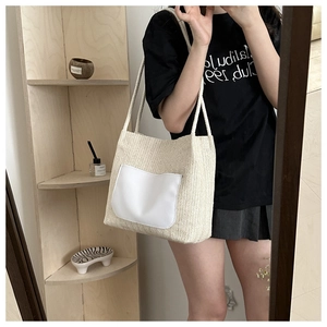 Détail d'un grand sac cabas tissé crème avec poche rectangulaire et doubles bandoulières