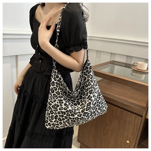 Hobo style leopard print canvas bag shown on shoulder for daily fashion use