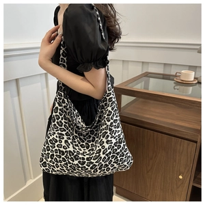 Close-up of leopard print canvas tote bag on model showing large capacity and soft texture