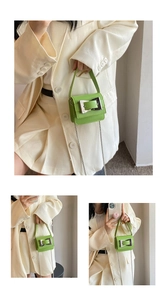 Macro detail of a green mini PU leather bag with a stylish silver square buckle accent