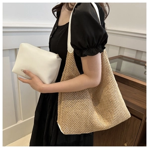 Detail of woven straw tote bag with white leather straps and matching zip clutch set