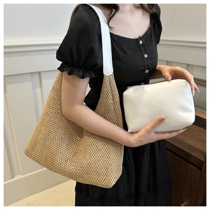 Detail of woven straw tote bag with white leather straps and inner zipper pouch