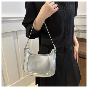 Silver metallic hobo bag on shoulder, minimalist crescent shape with adjustable strap