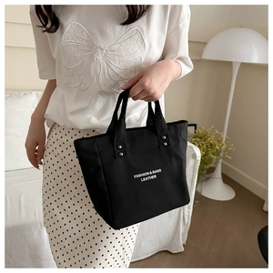 Minimalist black canvas tote bag with fashion lettering and silver rivet details