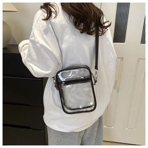 Rear view of a model wearing the clear PVC crossbody bag with black trim and adjustable strap