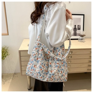 Detail view of the floral canvas tote bag showing its wide shoulder strap and spacious design