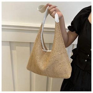 Detail of hollow woven straw shoulder bag with white leather straps for summer style