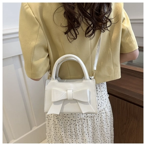Close-up of a white fashion crossbody bag featuring a chic 3D bow and delicate PU texture