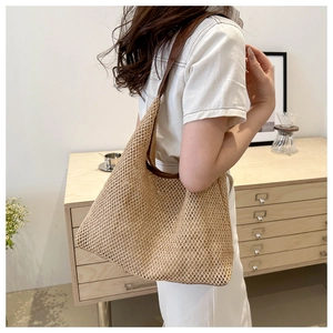 Detailed texture of woven straw shoulder bag with durable brown leather strap