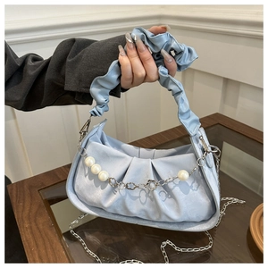 Detailed view of light blue ruched handbag with pearl chain and shimmering texture