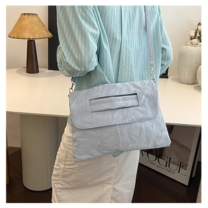 Détail d'un sac à bandoulière bleu clair à texture froissée et poignée intégrée