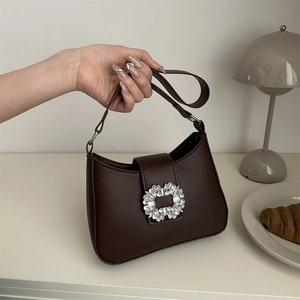 Dark brown leather half-moon underarm bag with a sparkling crystal buckle detail
