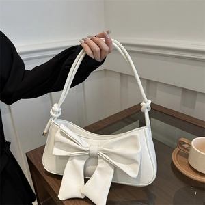 White faux leather shoulder bag with large bow and crocodile pattern for women