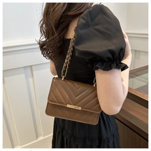Nahaufnahme der braunen gesteppten PU-Handtasche mit V-Stich-Muster und goldener Kette