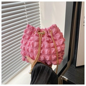 Dettaglio della borsa a secchiello plissettata rosa con trama a bolle e perle