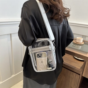 Waterproof clear PVC crossbody bag with adjustable silver strap shown on a model