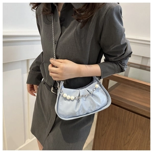 Detail of light blue pleated cloud bag with silver chain and pearl decoration