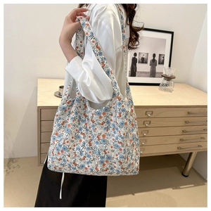 Close-up of floral tote bag worn by a model in a minimalist aesthetic interior