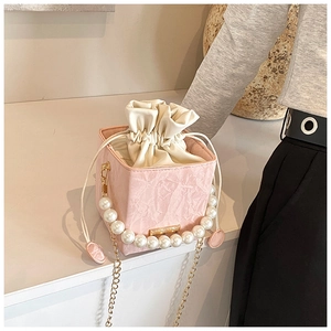 Detailed macro view of pink marble texture bucket bag with pearl handle and gold chain