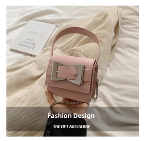 Detailed shot of pink leather handbag featuring a silver bow clasp and chain strap
