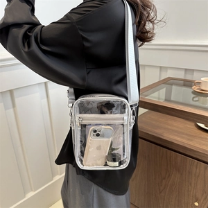 Transparent PVC crossbody bag with grey trim and adjustable wide strap on model