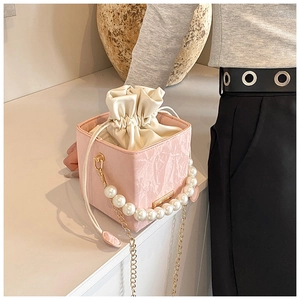 Detail of pink marble pattern PU bag with pearl handle and golden chain strap