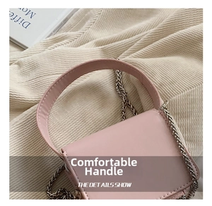 Detailed close-up of pink leather mini bag featuring silver chain strap and top handle