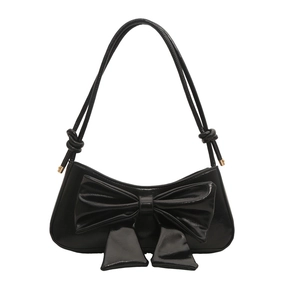Glossy black patent leather shoulder bag with large bow and rope strap on white background