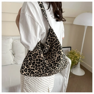 Detail of trendy leopard print tote bag on shoulder against minimalist interior background