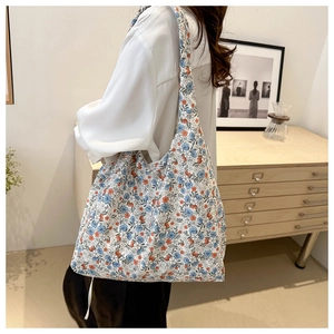 Detail of canvas tote bag with blue and orange floral prints and wide shoulder strap