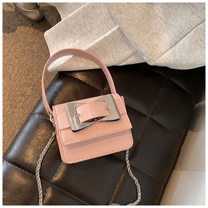 Close-up of pink mini crossbody bag featuring a large silver buckle and chain strap