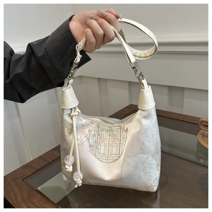 Détail de la broderie florale sur sac à main style néo-chinois avec pompon perlé