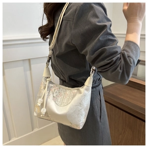 Détail d'un sac bandoulière en soie au style chinois avec motifs floraux et pompon élégant