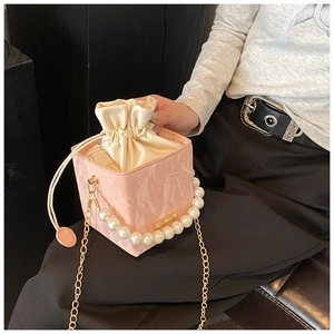 Detailed view of pink marble pattern square bucket bag with pearl handle and chain strap