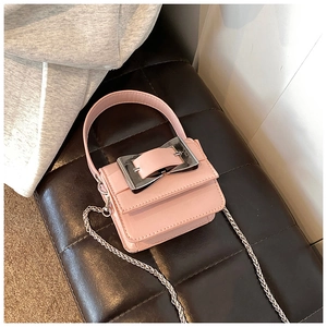 Detail of pink mini crossbody bag featuring large silver square buckle and chain strap