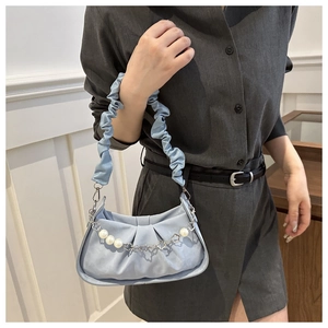 Detail of light blue pleated handbag featuring pearl and floral metal chain strap