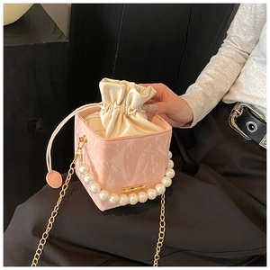 Pink marble bucket bag featuring a large pearl handle and golden chain detail