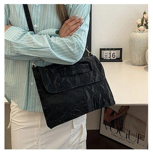 Sac fourre-tout noir plissé à texture brillante vue de côté élégante sur un mannequin