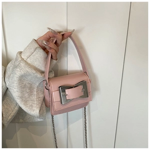 Macro detail of pink mini crossbody bag with polished silver clasp and metal chain strap