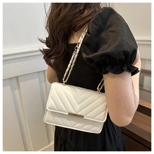 Detail der weißen Stepptasche mit V-Nähten und goldenem Metallverschluss für Damen