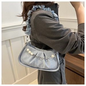 Detail of light blue pleated handbag with pearl chain and ruffled shoulder strap