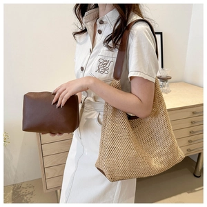 Detail of woven straw tote bag and brown leather pouch set worn by a female model